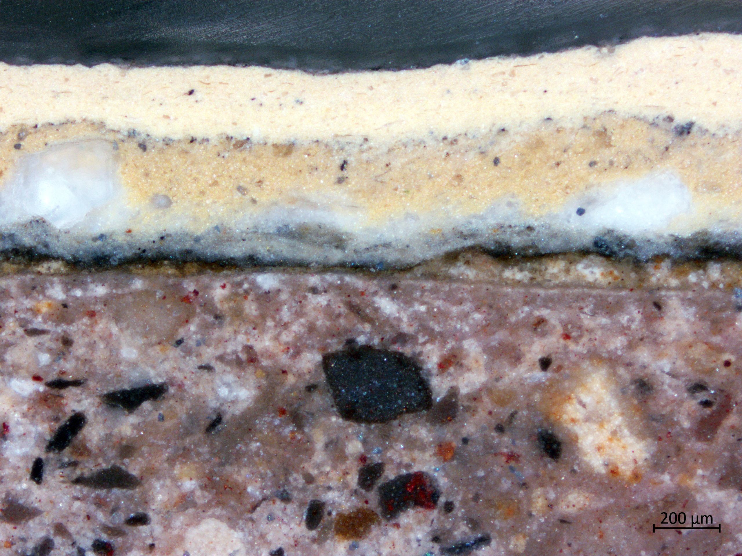 Querschliff Fassadengesims mit bauzeitlicher gelbbrauner Fassung, darüber jüngere Anstrichschichten in Hellgelb