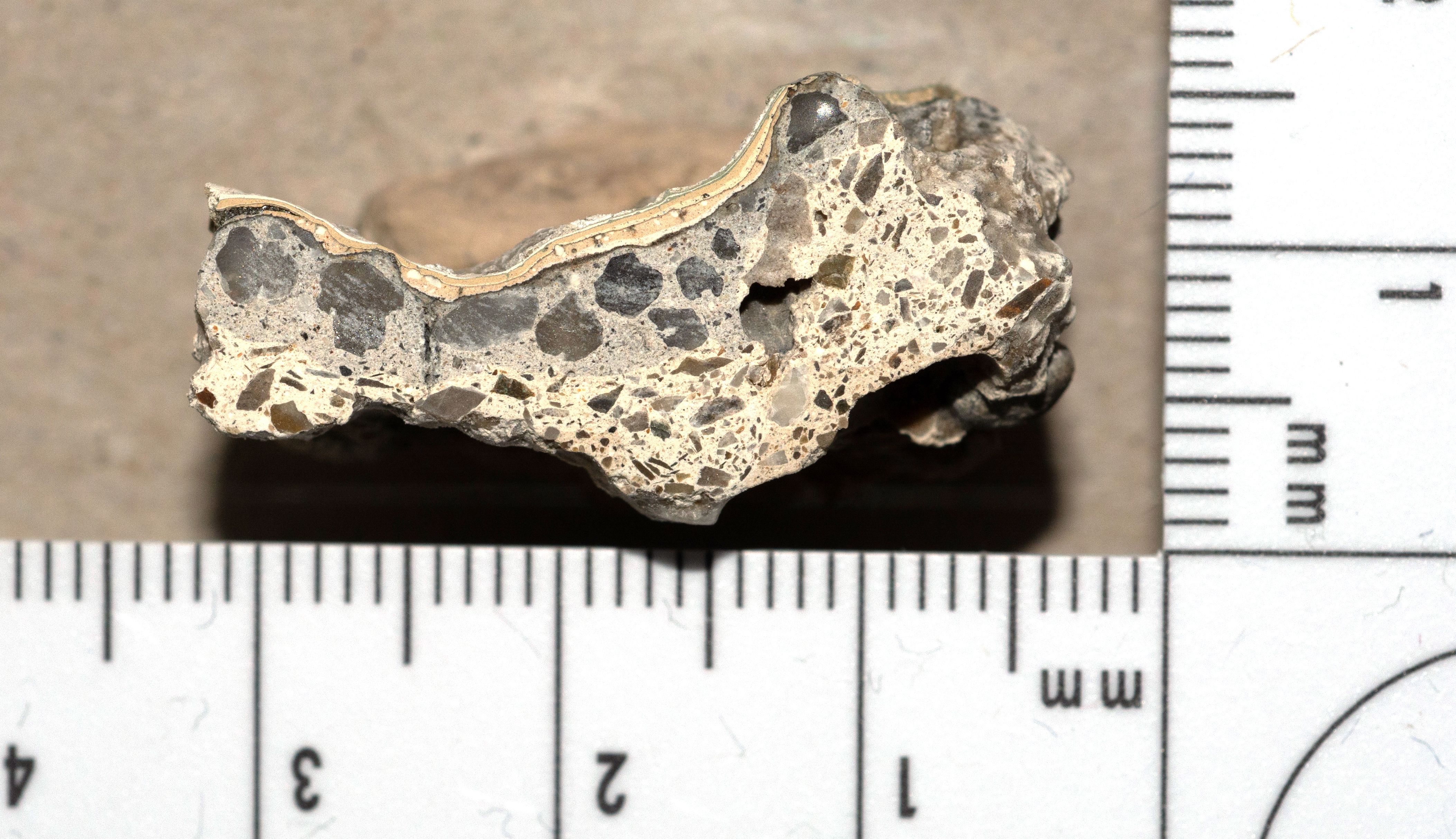 Querschliff Fassadenputz von 1911, bauzeitlich putzsichtige hellgraue Fassade, jüngere Anstriche in Gelbtönen und Weiß